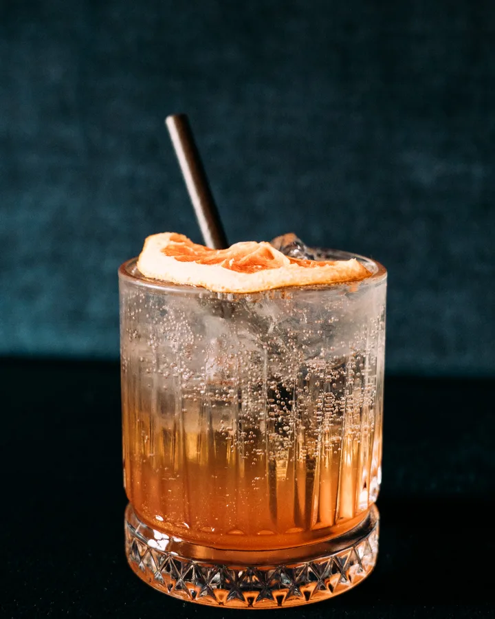 The Greatest Spritz – bernsteinfarbener Spritz mit Grapefruit und Rhabarber im Kristallglas in der Adieu Bar Berlin