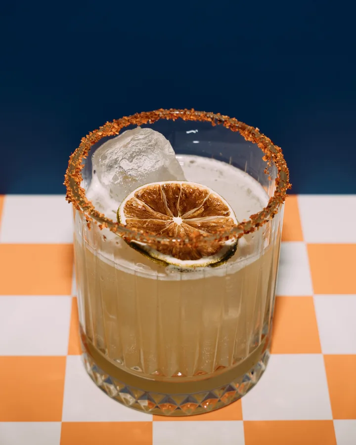 Spicy Margarita mit Chili-Salzrand und getrockneter Limette auf orange-weißem Karo in der Adieu Bar Berlin