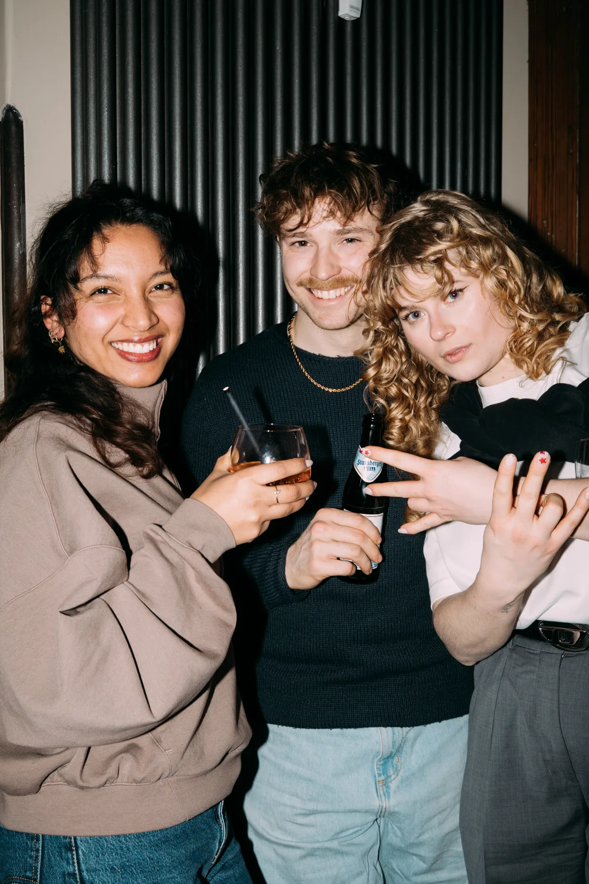 Drei Freunde mit Drinks in der Adieu Bar